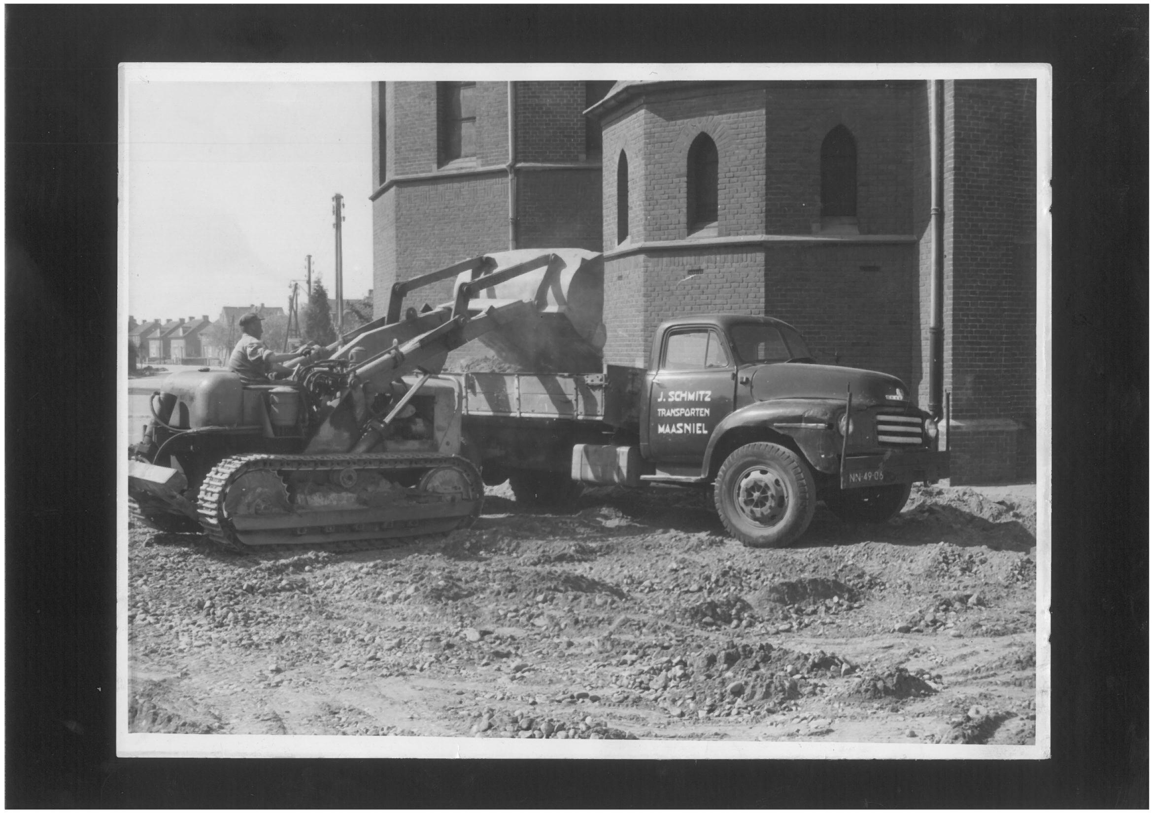 J.Schmitz vrachtwagen+bulldozer, kerk op achtergrond (1)